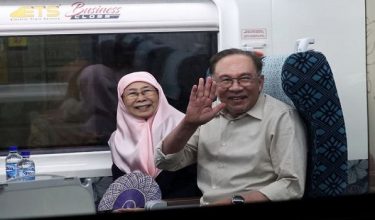 Perdana Menteri Datuk Seri Anwar Ibrahim (kanan) bersama isteri, Datuk Seri Dr Wan Azizah Wan Ismail melambaikan tangan sebaik menaiki ETS di JB Sentral hari ini selepas menamatkan lawatan santai bersama keluarga di Johor sejak semalam. / BERNAMA