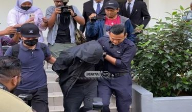 Tertuduh diiringi polis ketika meninggalkan mahkamah