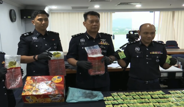 CRISTOPHER (tengah) menunjukkan peket pelbagai jenis dadah yang dirampas dalam serbuan