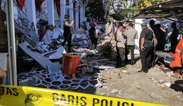 Anggota polis memeriksa bangunan KONI rosak akibat gempa di Manado/Foto AFP