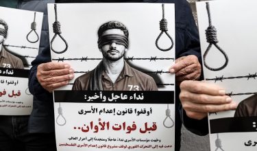 Protesters hold placards reading "Urgent and final appeal : Stop the execution of Prisoners Law before it's too late" outside the Red Cross offices in Ramallah, in the Israeli-occupied West Bank, on March 31, 2026, during a rally against a bill approved by Israel's parliament that would allow the execution of Palestinians convicted on terror charges for deadly attacks. Israel's parliament approved a bill on March 30, that would allow the execution of Palestinians convicted on terror charges for deadly attacks, a move that has been criticised as discriminatory and immediately drew a court challenge. The bill would make the death penalty the default punishment for Palestinians in the Israeli-occupied West Bank found guilty of intentionally carrying out deadly attacks deemed "acts of terrorism" by an Israeli military court. (Photo by Zain JAAFAR / AFP)