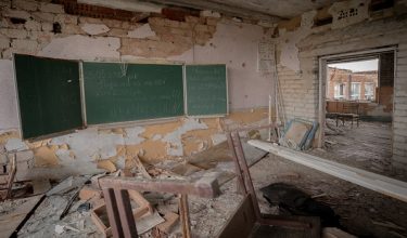 This photograph shows a chalkboard with the inscription "2023-2024 Year of Victory, Glory to Ukraine" inside a destroyed school in the village of Dovhenke, Kharkiv region, on May 1, 2026, amid the Russian invasion of Ukraine. (Photo by Ivan SAMOILOV / AFP)