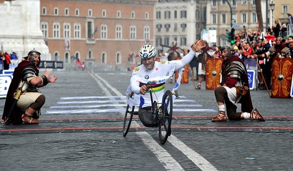 (FILES) Former driver and paracyclist Alex Zanardi celebrates as he crosses the fininsh line of the 20th Marathon of Rome on March 23, 2014. Alex Zanardi, the Italian racing car driver who became a Paralympic cycling champion after losing both legs in an accident, has died aged 59, his family announced on May 2, 2026. Zanardi, one of his country's most loved and respected sportsmen, who as credited with helping transformed the perception of disability in Italy, died on the evening of May 1. (Photo by Tiziana FABI / AFP)