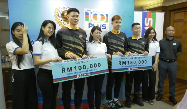 Pengarah Pemasaran F&N Beverages Marketing Sdn Bhd Leong Wai Yin menyampaikan insentif kepada Duta 100PLUS, Aaron Chia, Soh Wooi Yik dan Lee Zii Jia