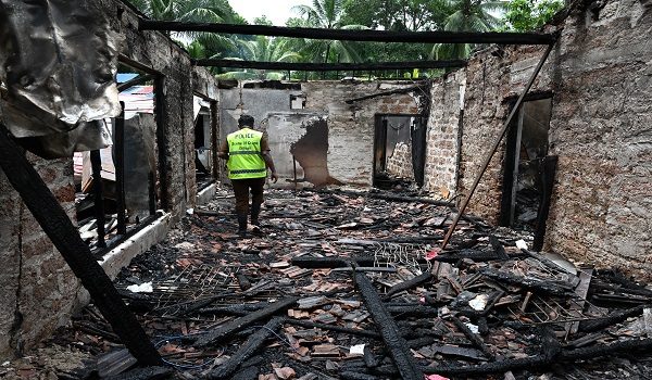 A Sri Lankan Scene of Crime Officer (SOCO) inspects the burnt house a day after a fire broke out at an elder care home in Batagoda on June 4, 2026. The manager of a Sri Lankan care home was arrested June 4, a day after a fire killed 12 residents and injured six others, officials said. (Photo by Ishara S. KODIKARA / AFP)
