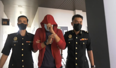Tertuduh, Ahmad Emin Nazrul Ahmad Nazrin (tengah) ketika dibawa ke Kompleks Mahkamah Kota Bharu hari ini.