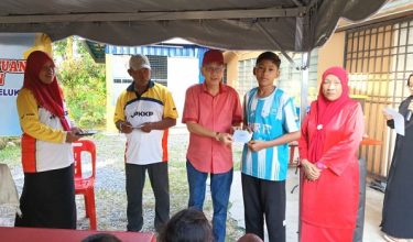 Pengerusi JPKKP Kampung Baru Belukar, Adli Abd Rahman menyampaikan sumbangan persekolahan