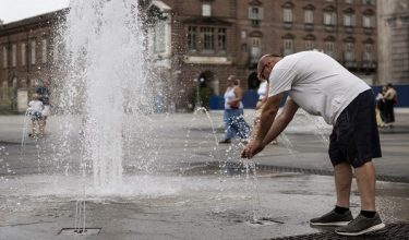 A person cools off in a public fountain in Piazza Castello during a heatwave in Turin, on August 3, 2026. After hitting western Europe at the start of last week, the season's latest heatwave roasted central Europe and on Saturday began to reach into Italy. (Photo by Marco Bertorello / AFP)