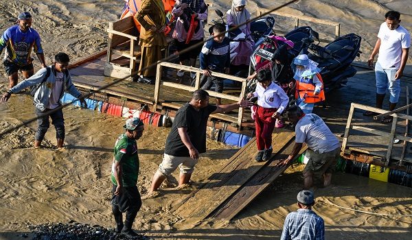 Sekumpulan kanak-kanak turun dari rakit di Sungai Peusangan susulan kejadian banjir kilat yang memusnahkan beberapa kampung berhampiran di daerah Bireuen. Foto AFP