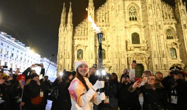 Ballerina Itali Nicoletta Manni membawa Obor Olimpik Musim Sejuk 2026 tiba di Piazza del Duomo