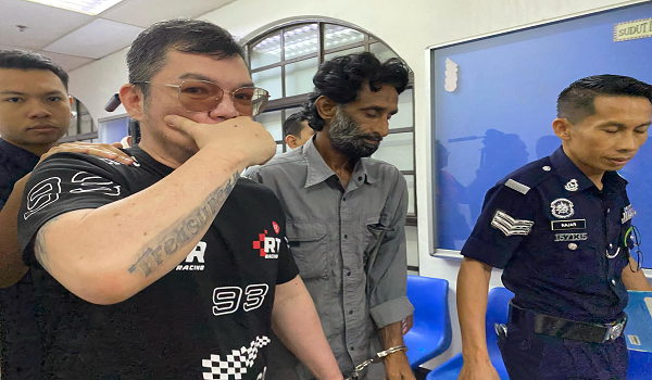 Tertuduh, Tan Ban Choon, 48 tahun diiringi polis ketika tiba di mahkamah