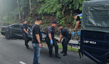 Polis mengusung mayat suspek utama kes samun yang ditembak mati di Jalan Bukit Tunku, di sini awal pagi tadi / Foto BERNAMA