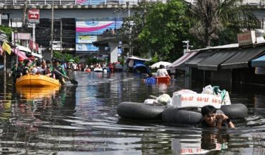 Seorang penduduk meredah banjir menarik bekalan makanan dan barangan keperluan miliknya di daerah Bang Kapi, Bangkok/Foto AFP