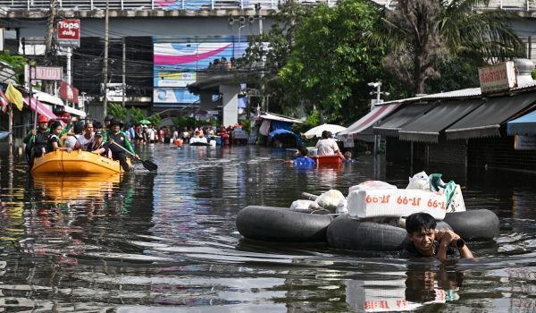 Seorang penduduk meredah banjir menarik bekalan makanan dan barangan keperluan miliknya di daerah Bang Kapi, Bangkok/Foto AFP