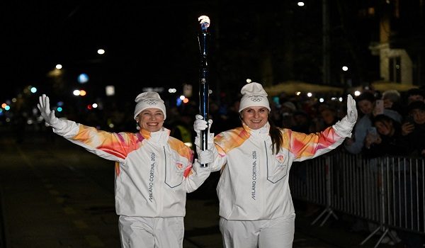 Manuela Di Centa dan Gerda Weissensteiner membawa obor Olimpik di luar stadium semasa upacara pembukaan temasya Olimpik Musim Sejuk Milano Cortina 2026/ REUTERS