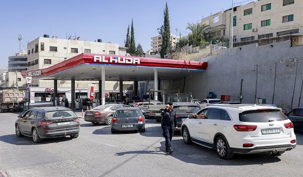 A Palestinian traffic policeman directs vehicles queueing outside a congested petrol station in the city of Nablus in the occupied West Bank on June 13, 2025. (Photo by Jaafar ASHTIYEH / AFP)