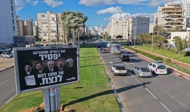 Cars drive past an election billboard of Israel's Likud party bearing portraits of (L-R) Iran's supreme leader Ayatollah Mojtaba Khamenei, Mayor of the New York City Zohran Mamdani, Palestinian President Mahmoud Abbas, Turkey's President Recep Tayyip Erdogan and Hezbollah Secretary-General Naim Qassem with a message in Hebrew reading 'They want Netanyahu to lose, Don't let them win', ahead of country's legislative elections, in Netanya on October 6, 2026. Israel heads to the polls on October 27 in its first election since the October 7, 2023 Hamas-led attack, in what is seen as a referendum on Israel's Prime Minister Benjamin Netanyahu. (Photo by JACK GUEZ / AFP)