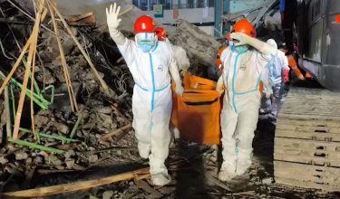 Pasukan penyelamat mengusung mayat mangsa dari lokasi runtuhan sekolah / AFP