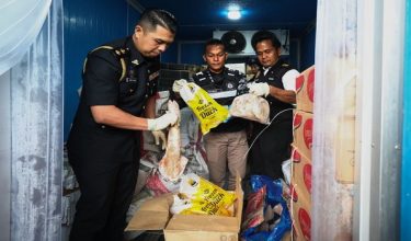 Ketua Pegawai Penguatkuasa, Kementerian Perdagangan Dalam Negeri dan Kos Sara Hidup (KPDN) Cawangan Sandakan, Azdy Zukkry John (kiri) dan Pegawai Kesihatan Persekitaran Pejabat Kesihatan Kawasan Sandakan Ts. Sundusin Nganro (kanan) melihat daging babi dan ayam yang bercampur dalam sebuah kontena sewaktu operasi bersepadu bersama Jabatan Perkhidmatan Veterinar dan Kementerian Kesihatan di sebuah premis / BERNAMA