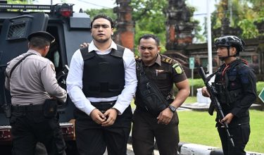Australian suspect Mevlut Coskun (C) arrives to attend his verdict hearing at a courtroom in Denpasar, on Indonesia's Bali island, on March 9, 2026. The trial of three Australians accused of plotting the murder of a compatriot at a villa in Bali continues, with all facing the death penalty. (Photo by SONNY TUMBELAKA / AFP)