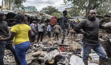 People walk around damaged property looking for salvageables in downtown Nairobi following a night of heavy rainfall that resulting in heavy flooding around Nairobi on March 07, 2026. (Photo by Tony KARUMBA / AFP)