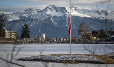 This photograph shows a Swiss flag at half-mast as a sign of national mourning at the resort in Crans-Montana on January 6, 2026, following the devastating New Year bar blaze. Swiss local authorities admitted on January 6, 2026 they failed to conduct periodic fire and safety inspections over the past five years at a bar where an inferno killed 40 people and injured 116 others. (Photo by Fabrice COFFRINI / AFP)