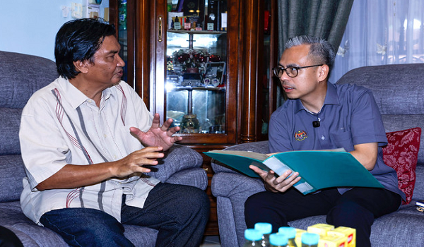 Menteri Komunikasi merangkap jurucakap Kerajaan Perpaduan, Datuk Fahmi Fadzil (kanan) beramah mesra dengan Bekas Ketua Pengarang Melaka Hari Ini Ishak Mohamed Salleh, 65, pada majlis Penyerahan Sumbangan Tabung Kasih@HAWANA,