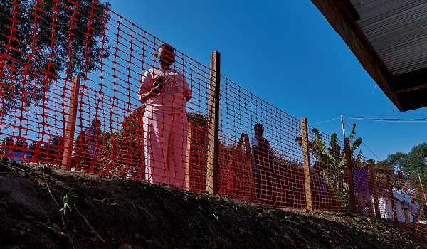 People look through a safety cordon red-line at the Evangelical Medical Center (CEM), one of the facilities at the forefront of the response to the Ebola outbreak, as agencies intensify efforts to contain a new Ebola outbreak caused by the Bundibugyo virus strain, in Bunia, Ituri province, Democratic Republic of Congo, May 31, 2026. REUTERS/Gradel Muyisa Mumbere