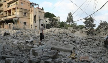 A man stands amid debris following Israeli airstrikes that hit the previous day, near the archaeological site of the Roman hippodrome in the southern Lebanese city of Tyre on June 8, 2026. On June 7, the Israeli military issued an evacuation warning for most of Tyre and its surroundings. The coastal city shelters thousands of displaced people and has been heavily bombed since the fighting began. (Photo by KAWNAT HAJU / AFP) /