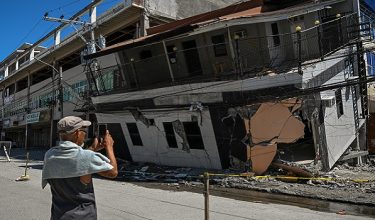 A man takes a photo of a collapsed building after a 7.8 magnitude earthquake in General Santos City on June 9, 2026. A 7.8-magnitude earthquake in the southern Philippines on June 8 killed at least 35 people, according to provincial authorities, after toppling buildings and sparking tsunami warnings across the region. (Photo by Jam STA ROSA / AFP)