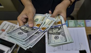 A money changer counts US Dollar notes at a money exchange office in Jakarta on May 12, 2026, amid the Rupiah's depreciation against the USD. (Photo by BAY ISMOYO / AFP)