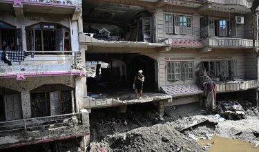 A man looks at the remains as he stands inside a damaged and sludge-ridden house in the aftermath of the flash floods at Devighat in Nepal's Nuwakot district on September 8, 2026. The August 26 glacial and mountain collapse on the China-Nepal border killed at least 1,398 people, with more than 5,500 missing, including around 800 foreigners. (Photo by Pedro PARDO / AFP)