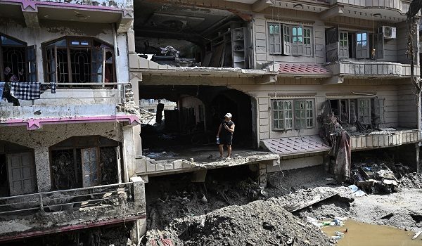 A man looks at the remains as he stands inside a damaged and sludge-ridden house in the aftermath of the flash floods at Devighat in Nepal's Nuwakot district on September 8, 2026. The August 26 glacial and mountain collapse on the China-Nepal border killed at least 1,398 people, with more than 5,500 missing, including around 800 foreigners. (Photo by Pedro PARDO / AFP)