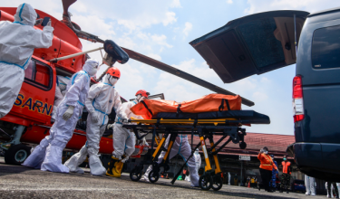 Pegawai penyelamat membawa beg mayat yang mengandungi jasad mangsa nahas kapal Virgo Transport 8 selepas tiba dengan helikopter di Lapangan Terbang Syamsudin Noor, Banjarmasin, Kalimantan Selatan, hari ini.