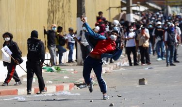 Seorang penunjuk perasaan melempar batu ke arah pasukan keselamatan ketika demonstrasi antikerajaan memasuki minggu ketiga di Madagascar/ REUTERS