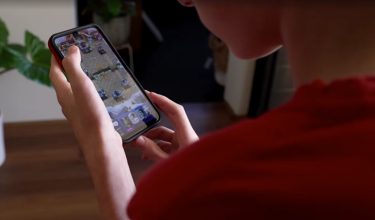 Seorang remaja 14 tahun sedang bermain permainan video di telefon bimbitnya / REUTERS