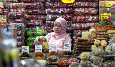 Peniaga membungkus keropok kering untuk dijual kepada pelanggan