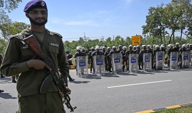 Riot policemen line up along a road near the expected venue of the US-Iran talks in the Red Zone area of Islamabad on April 10, 2026. As Iranian and US envoys prepare to hold talks in Islamabad to end the Middle East war, official sources and experts say Beijing helped pave the way for the negotiations and will be a crucial component in securing a permanent truce. (Photo by Aamir QURESHI / AFP)