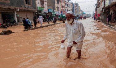 Seorang penduduk meredah jalan yang dinaiki air selepas hujan susulan musim monsun di Karachi, Pakistan/ Foto REUTERS