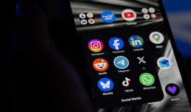 This photograph shows a set up smart-phone screen displaying the logo of main social media platforms including Instagram, Facebook, LinkedIn, Reddit, Telegram, X, Bluesky, Tiktok and Whatsapp in Saint-Mande, east of Paris, on April 29, 2026.  (Photo by Martin LELIEVRE / AFP)