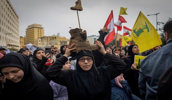 A woman places a symbolic boot on her head as a gesture of respect for a Lebanese fighter, as she takes part with demonstrators, including Hezbollah supporters, in a protest against the direct negotiation between the Israeli and Lebanese governments, in Beirut, Lebanon, April 10, 2026. REUTERS/Adnan Abidi     TPX IMAGES OF THE DAY