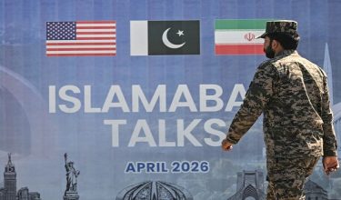 A Pakistani Ranger walks past a billboard for the US-Iran peace talks in Islamabad on April 12, 2026. Iran and the United States failed to reach an agreement to end the war in the Middle East, US Vice President JD Vance said on April 12 after marathon talks in Islamabad, adding that he was leaving negotiations after giving Tehran the "final and best offer". (Photo by Farooq NAEEM / AFP)