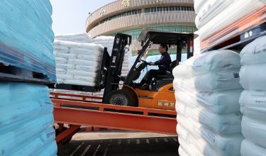 A worker operates a forklift moving bags of plastic pellets at a warehouse, as rising oil prices drive up production costs for plastic manufacturers, in Dongguan, Guangdong province, China, April 1, 2026.  REUTERS/Go Nakamura
