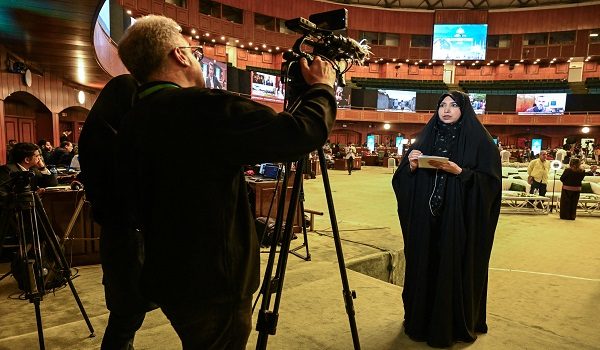 An Iranian journalist (R) reports from a media facilitation center during USIran peace talks in Islamabad on April 11, 2026. Senior Iranian and American delegations met Pakistani Prime Minister Shehbaz Sharif in Islamabad on April 11 to begin negotiations towards a deal to end the Middle East war unleashed six weeks earlier by US-Israeli strikes on Tehran. (Photo by Aamir QURESHI / AFP)