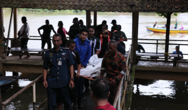 Mayat dua beradik dibawa naik oleh pasukan penyelamat / Foto RTM