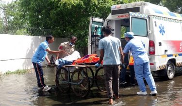 Pegawai perubatan sedang memindahkan mayat mangsa ke dalam ambulans di lokasi nahas. Foto AFP