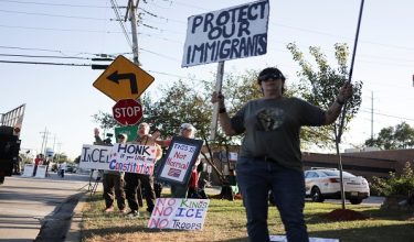 Orang ramai memegang plakad ketika berhimpun di hadapan kemudahan Imigresen dan Penguatkuasaan Kastam Amerika Syarikat (ICE) di Broadview, Illinois/ REUTERS