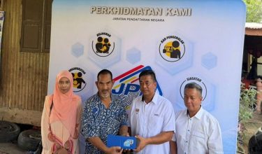 Ketua Pengarah Pendaftaran Negara menyerahkan MyKad kepada seorang pesawah di Kampung Keting, Gunong Bachok