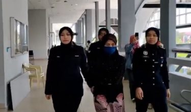 Tertuduh diiringi polis ketika meninggalkan mahkamah