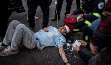 Petugas penyelamat membantu seorang mangsa selepas serangan ke atas sebuah bangunan di Dataran Enghelab, Tehran. - Foto AFP